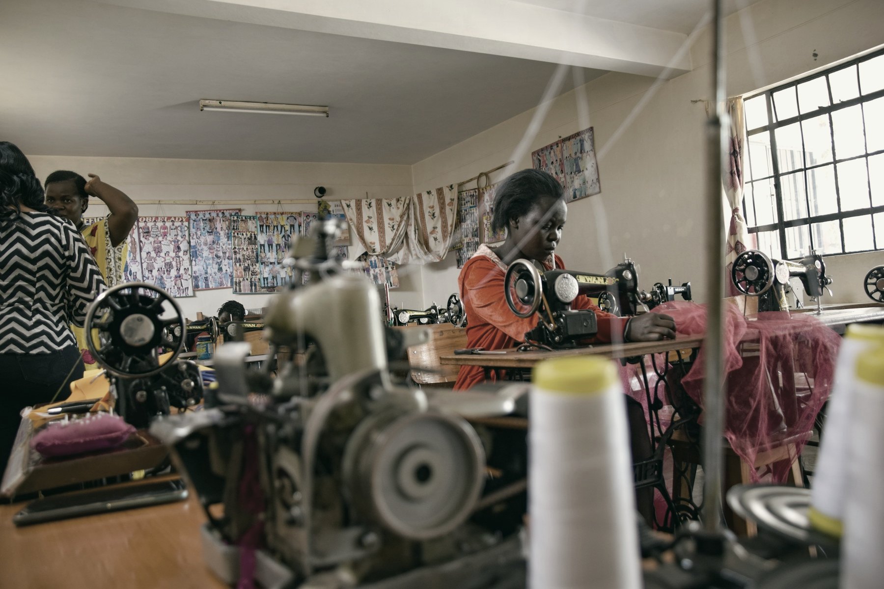 A busy workshop with people working at sewing machines